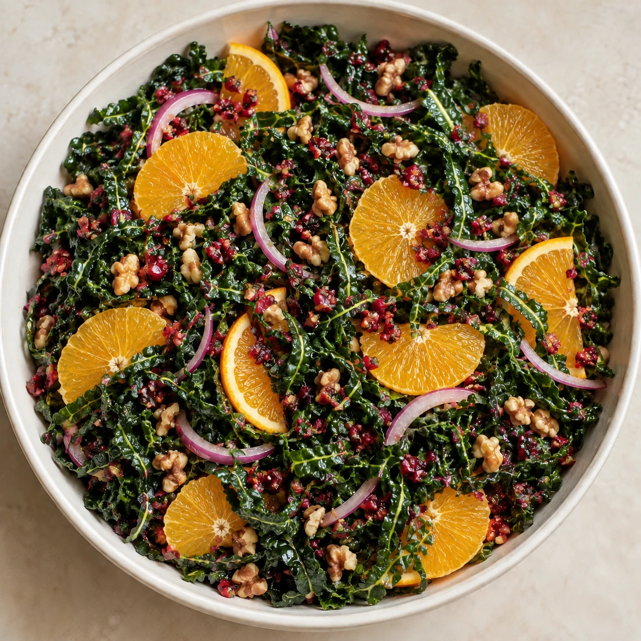 Overhead view of kale cranberry-orange salad with prepared walnuts