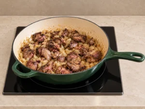 Chicken livers with browned edges and softened onion in an Artichaut skillet