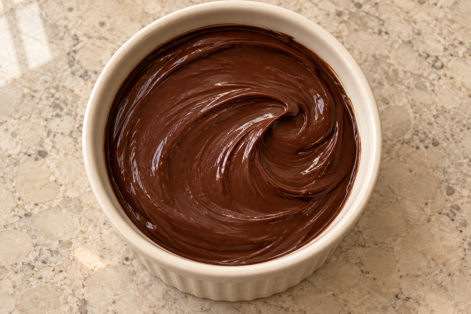 Overhead view of smooth glossy Full GAPS cocoa ganache holding a curved spoon trail
