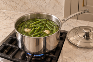 Cut string beans simmering in dill garlic vinegar brine in a Le Creuset stainless saucepan