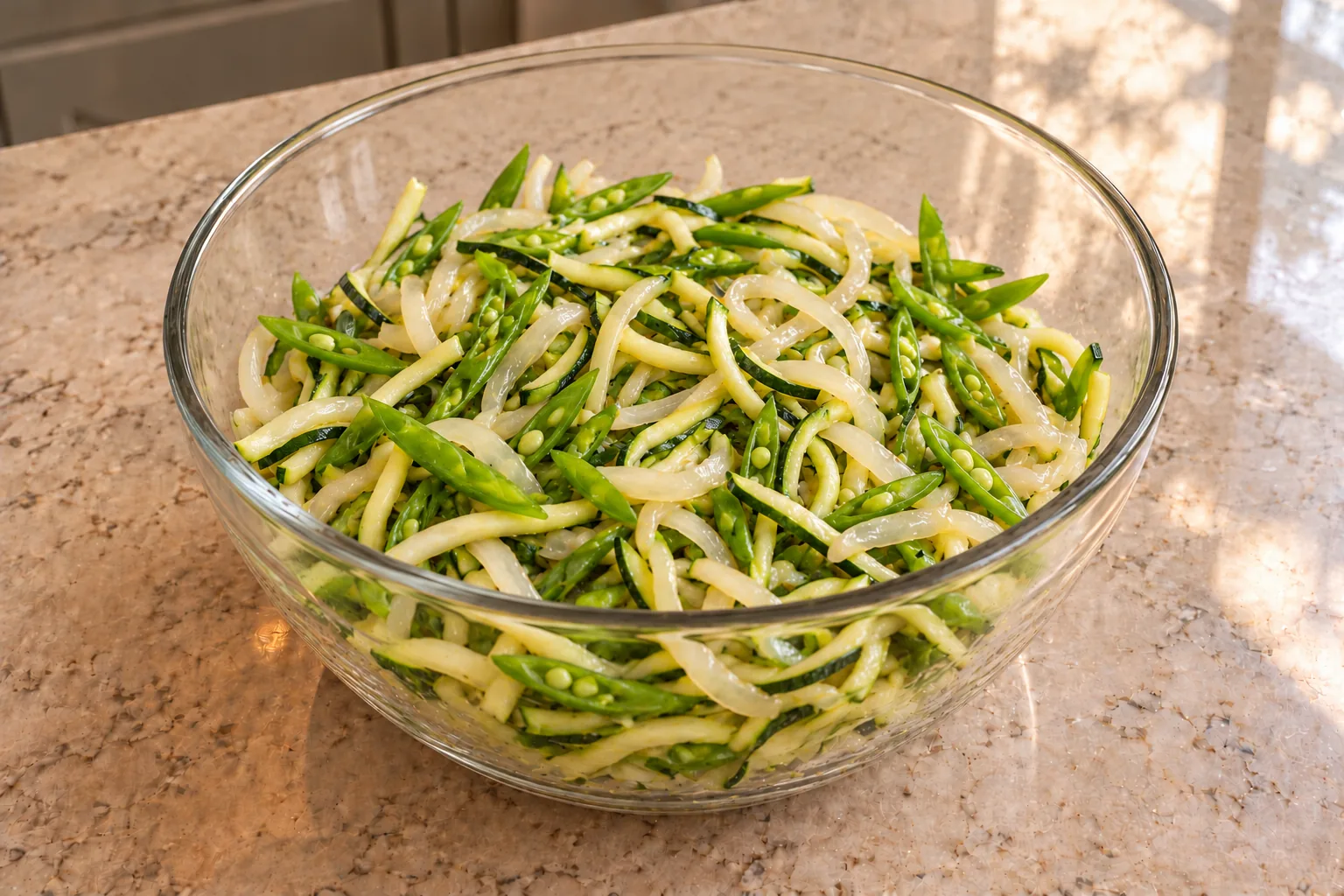 Drained zucchini strands, slivered snap peas and translucent onion ready to combine for Full GAPS chicken Pad Thai