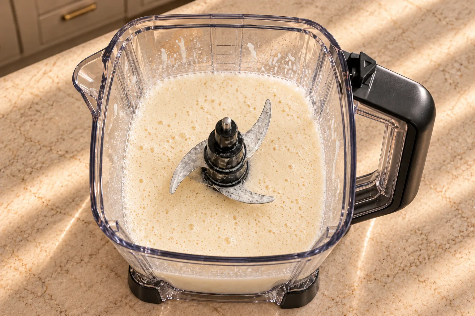 Used Ninja BN801 pitcher with thin foamy eggnog, splash residue and coated blades after blending