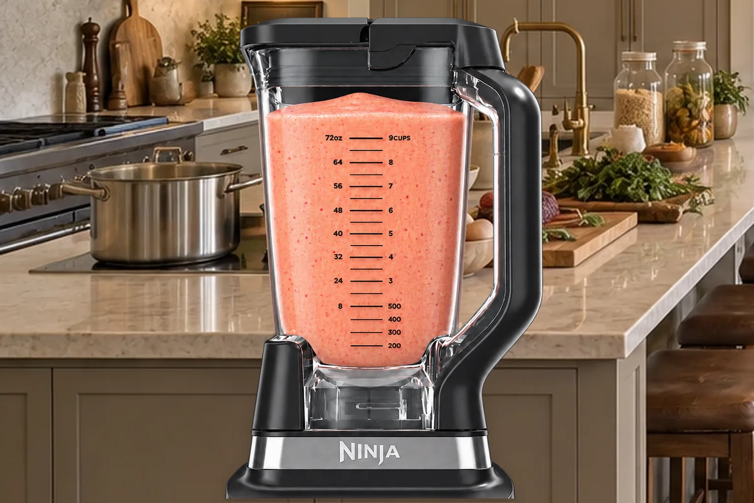 Smooth coral-pink strawberry orange banana smoothie in the stopped Ninja BN801 pitcher