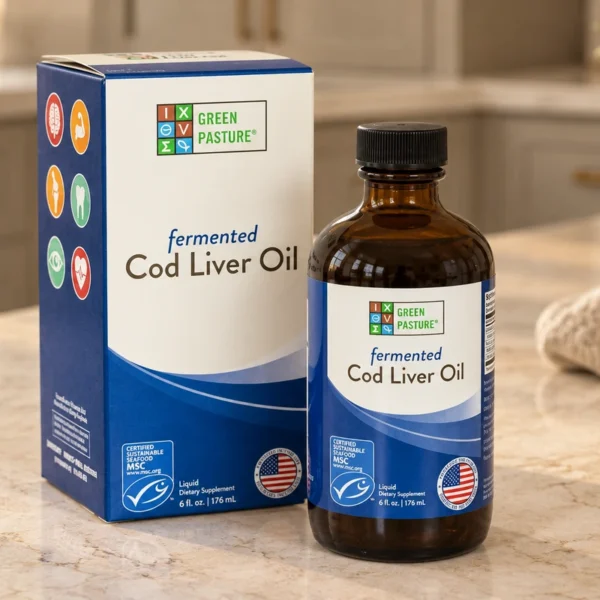 A closed Green Pasture fermented cod liver oil bottle and its carton on a cream stone surface.