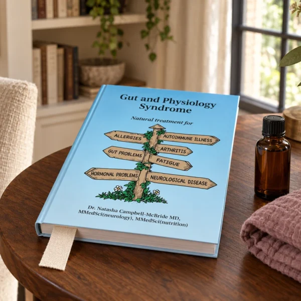 The 2020 Gut and Physiology Syndrome book beside an unlabeled amber oil bottle and folded pregnancy muslin.
