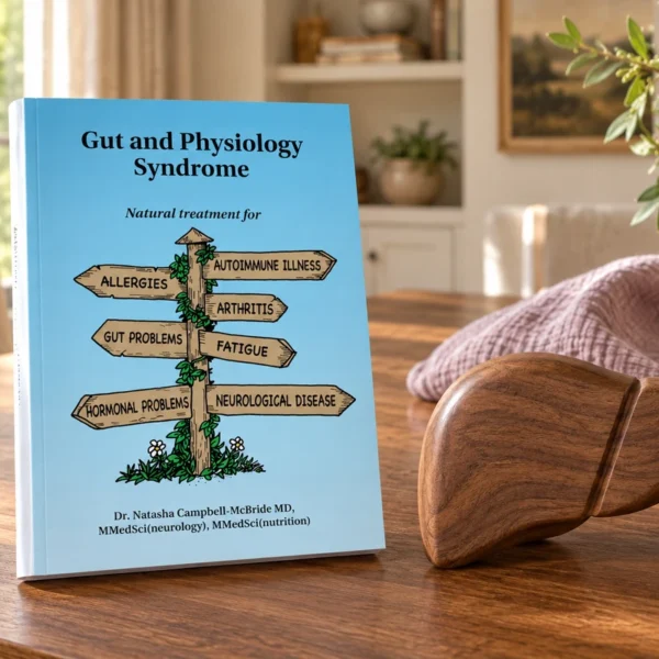 The Gut and Physiology Syndrome book beside a handcrafted wooden liver form and folded pregnancy muslin.